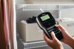 LM280 1815990-dymo-labelmanager-280-black-on-white-1in-storage-closet-close-up-of-hand-holding-label-maker-in-use